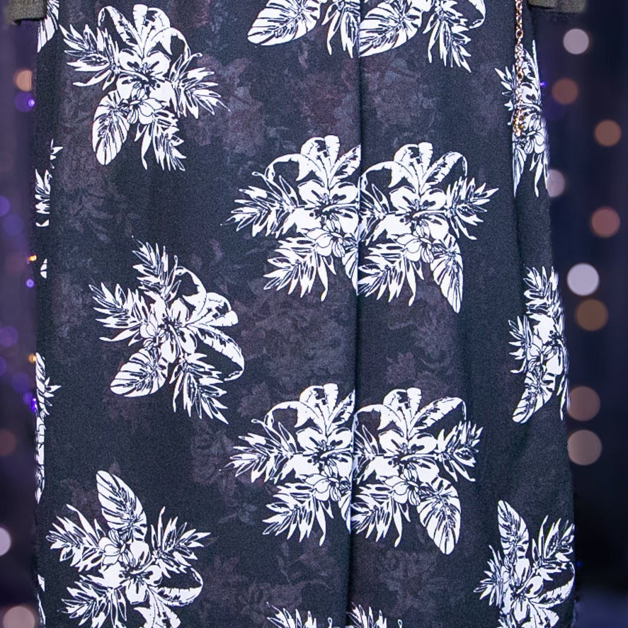 Black skirt with white floral pattern on a mannequin against a purple curtain background