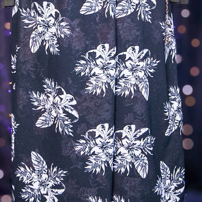 Black skirt with white floral pattern on a mannequin against a purple curtain background